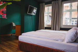 a bedroom with two beds and a green wall at friedrich DAS BETT in Braunschweig