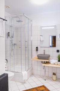 a bathroom with a shower and a sink and a tub at friedrich DAS BETT in Braunschweig