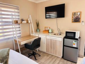 a room with a desk with a microwave and a tv at Sunset Heaven in Newcastle