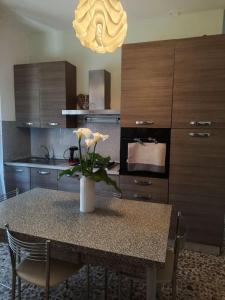 a kitchen with a table with a vase of flowers on it at Il nido in Cecina