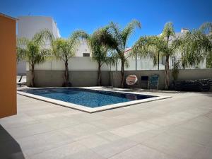a swimming pool in a courtyard with trees and a building at Apt IM - With pool, wifi and parking in Pêra