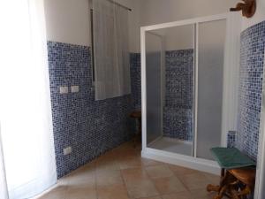 a bathroom with a shower with blue tiles at La Testa Fra Le Nuvole in Finale Ligure