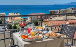 a table with breakfast food on a balcony with a view at Hotel Noris in Finale Ligure