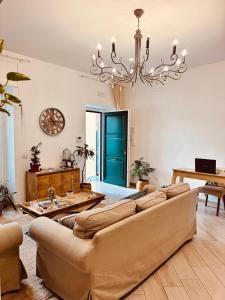 a living room with a couch and a chandelier at Palazzo Spasiano rooms - SORRENTO CENTER in Sorrento