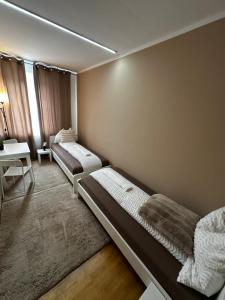 a room with two beds and a table and a chair at Zimmervermietung Linz 1 in Linz