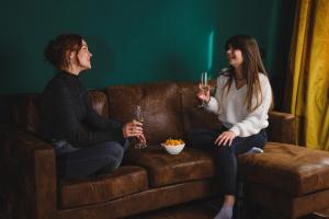 two women sitting on a couch with drinks at friedrich DAS BETT in Braunschweig
