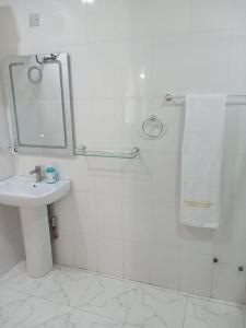 a bathroom with a sink and a shower with a mirror at PrimeAxishub in Ilorin