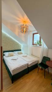 a bedroom with a large bed and a chandelier at Penzion Navara in Kolín