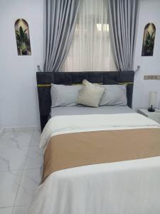 a bedroom with a large bed with a window at PrimeAxishub in Ilorin