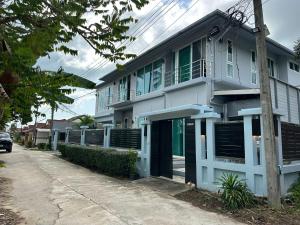 a white building with green shutters on a street at Villa Worawan Pool Villa Bo Phut in Nathon Bay