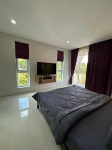 a bedroom with a bed and a flat screen tv at Villa Worawan Pool Villa Bo Phut in Nathon Bay