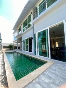 a house with a swimming pool in front of a house at Villa Worawan Pool Villa Bo Phut in Nathon Bay