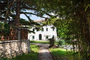 a pathway leading to a white house with a stone wall at Villa Guarienti Valpolicella in Fumane