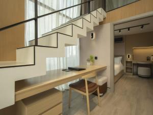 a room with a desk and a staircase with a bed at Luxury 2br Apt & Pool access in Panama City