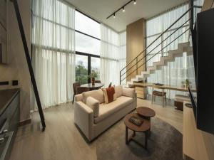 a living room with a white couch and a staircase at Luxury 2br Apt & Pool access in Panama City +30 photos