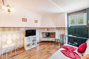 a living room with a fireplace and a tv at Casas da Biquinha in Sintra