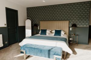 a bedroom with a large bed with blue pillows at Domaine de Thironne Lac & Nature in Montigny-le-Chartif +37 photos