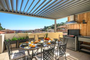 a patio with a table and chairs on a balcony at Le Coq Elysium - Exceptional 220 sqm Penthouse - Private Terrace & Jacuzzi - AC - 3 Parking Spaces in Menton