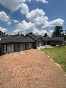a house with a brick driveway in front of it at Randhart guesthouse in Alberton