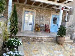 a house with a wooden porch with blue doors at Kranidi House. in Kranidi