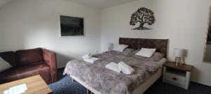 a bedroom with a bed and a chair at PENZION BENEŠOV u BROUMOVA in Broumov