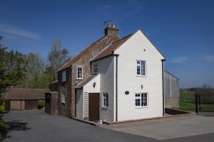 a large white house with a brick building at Lyke Wake Cottage in Northallerton