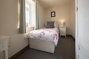 a small bedroom with a bed and a window at Lyke Wake Cottage in Northallerton