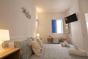 a bedroom with a bed with a desk and a window at Montebello Room's in Marettimo