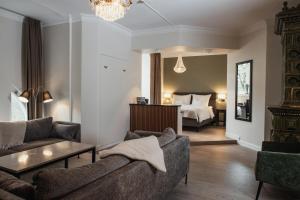 a living room with a couch and a bed at Home Hotel Norre Park in Halmstad