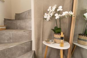 a side table with a vase of flowers on it at Montebello Room's in Marettimo +16 photos