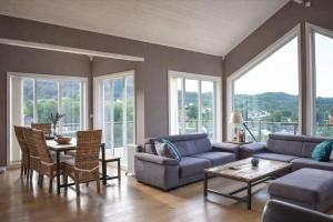 a living room with a couch and a table at Luxury Fjord Cabin with jacuzzi, boat dock & view in Sveio