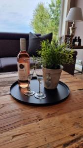a tray with a bottle and two glasses on a table at Luxury Fjord Cabin with jacuzzi, boat dock & view in Sveio +25 photos