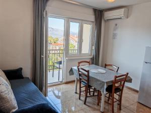 a dining room with a table and chairs and a window at Apartments Sofija in Slatine