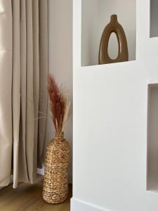a vase sitting on the floor next to a curtain at Le Cocon de Milan in Valras-Plage +19 photos