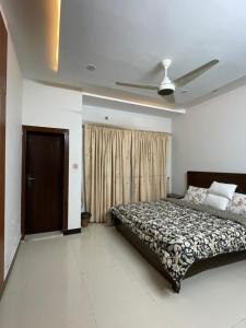 a bedroom with a bed and a ceiling fan at Ranim Family Lodge - Abbottabad in Abbottabad