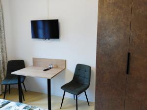 a room with a table and two chairs and a tv at Mein Wein Apartment in Krems an der Donau