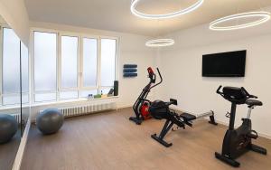 a gym with exercise bikes and a flat screen tv at Limehome Berlin Luise Henriette Str - Digital Access in Berlin