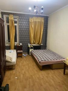 a bedroom with two beds and a window with yellow curtains at На Еврейской in Odesa