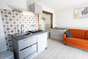 a kitchen with a sink and an orange couch at Nogica in Otočec
