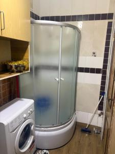 a shower in a bathroom with a washing machine at На Еврейской in Odesa