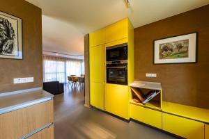 a kitchen with yellow cabinets and a yellow wall at Neue Büdnerei in Althagen