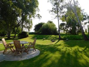 a patio with a table and chairs in the grass at Neue Büdnerei in Althagen