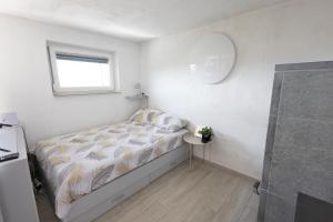 a small bedroom with a bed and a window at Nogica in Otočec