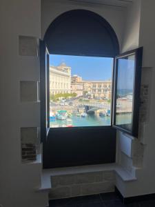 a window in a building with a view of a harbor at La Finestra sul Mare di Ortigia Suite Luxury in Syracuse