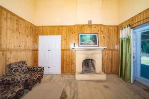 a living room with a fireplace and a chair at Forest Rest House Gahan in Bāgi