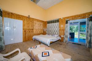 a bedroom with two beds in a room with wooden walls at Forest Rest House Gahan in Bāgi