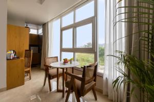 a dining room with a table and a large window at yashobhoomi Hostel in New Delhi