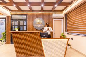 a man standing in front of a reception desk at yashobhoomi Hostel in New Delhi