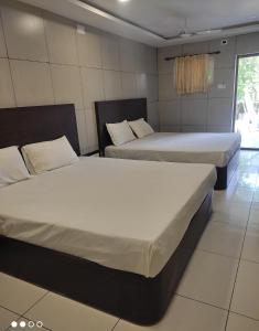 a room with two beds in a room at Abidharpp in Velankanni