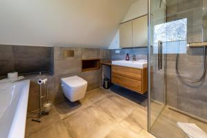 a bathroom with a toilet and a sink and a shower at Neue Büdnerei in Althagen +24 photos